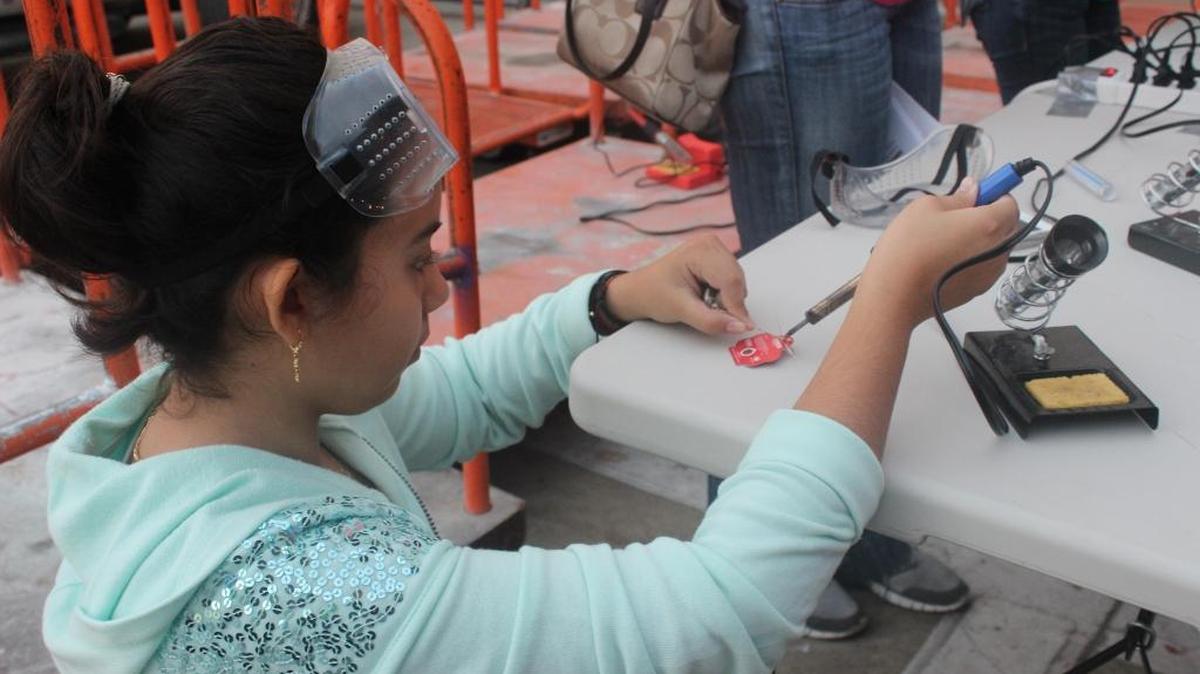 Vanessa Lima, learning how to use heat in order to make an LED blinking lapel.