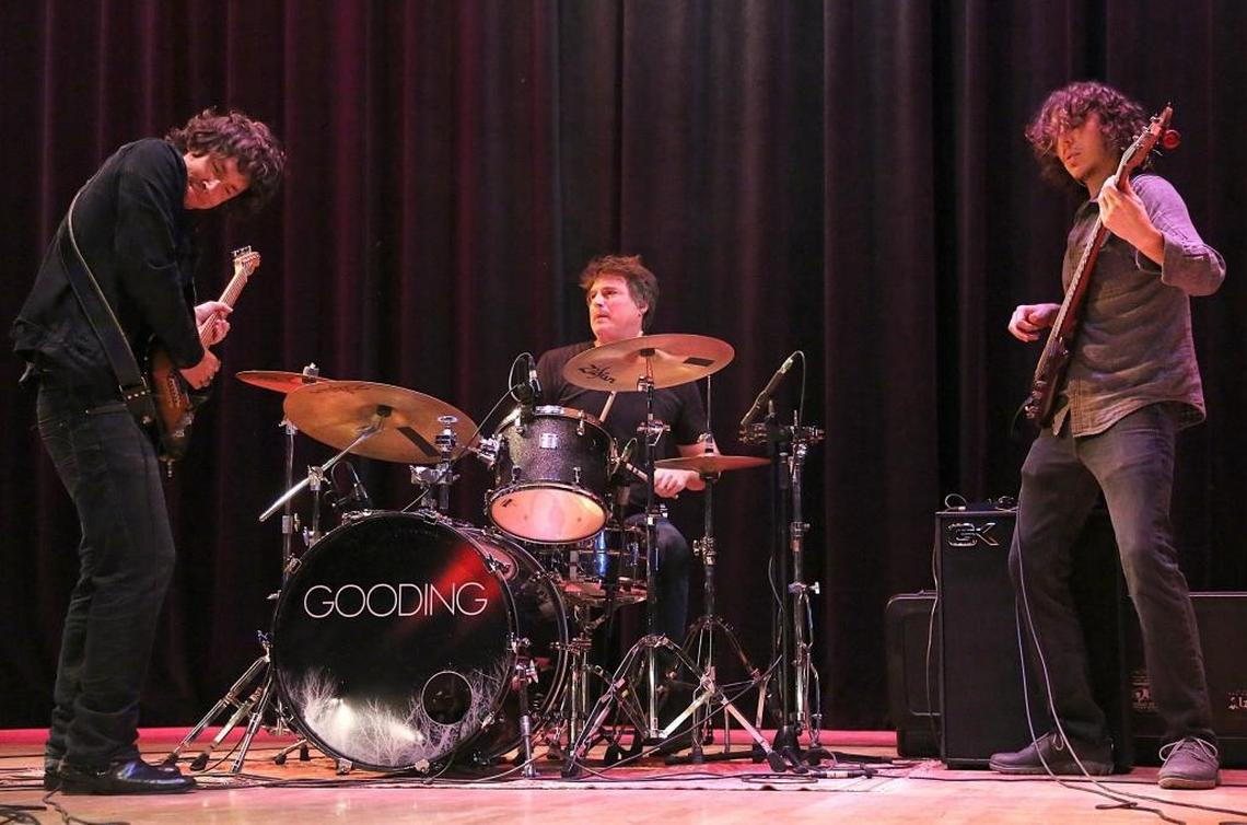 Steven Gooding, left, and his bandmates, Jesse Reichenberger, center, and bassist, Eric Santagada, right, jam as GOODING performs for students at Miami Senior High on Tuesday, October 17, 2017. The concert is part of an effort to teach teens about financial literacy.