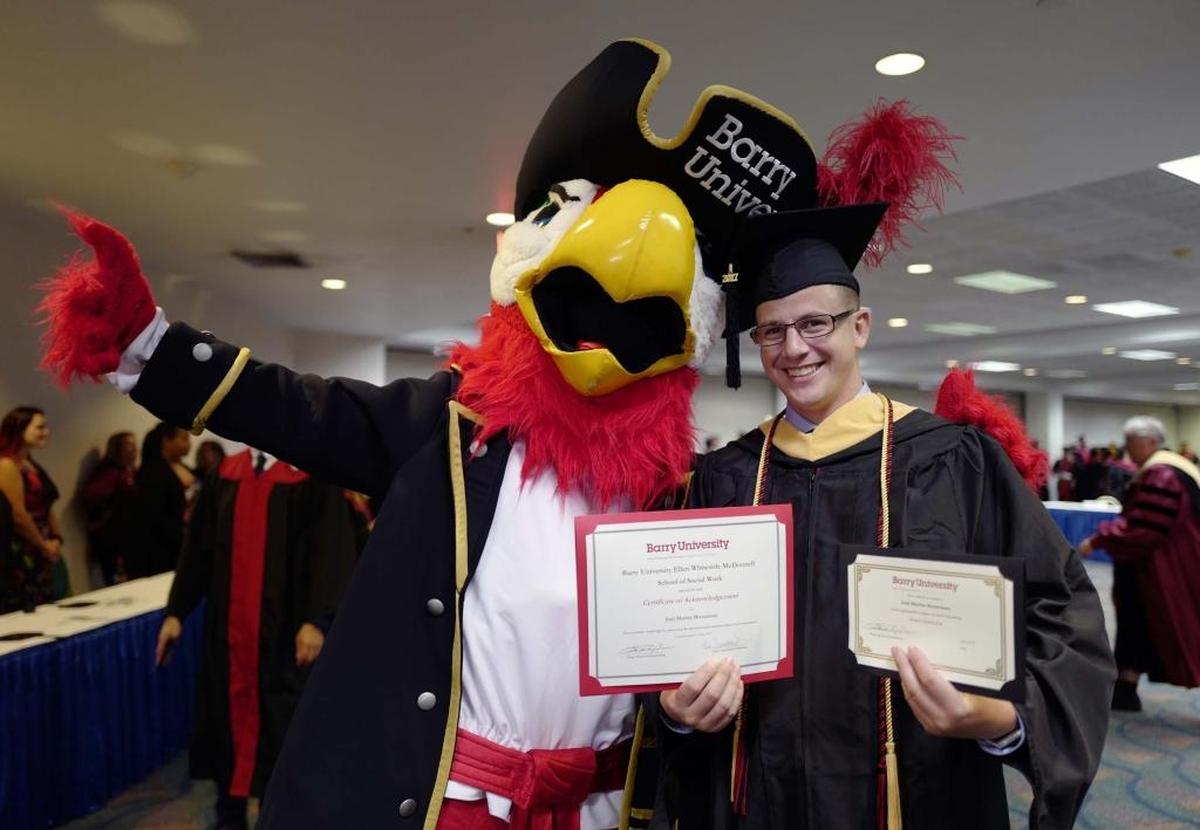 Joel Breneman with Bucky the Parrot, the Barry University Mascot, after a Barry University graduation at the James L. Knight Convention Center on Saturday, May 6, 2017. Breneman graduated from the School of Social Work, defying all odds after undergoing several heart surgeries during his time at Barry; two of them in this last semester.