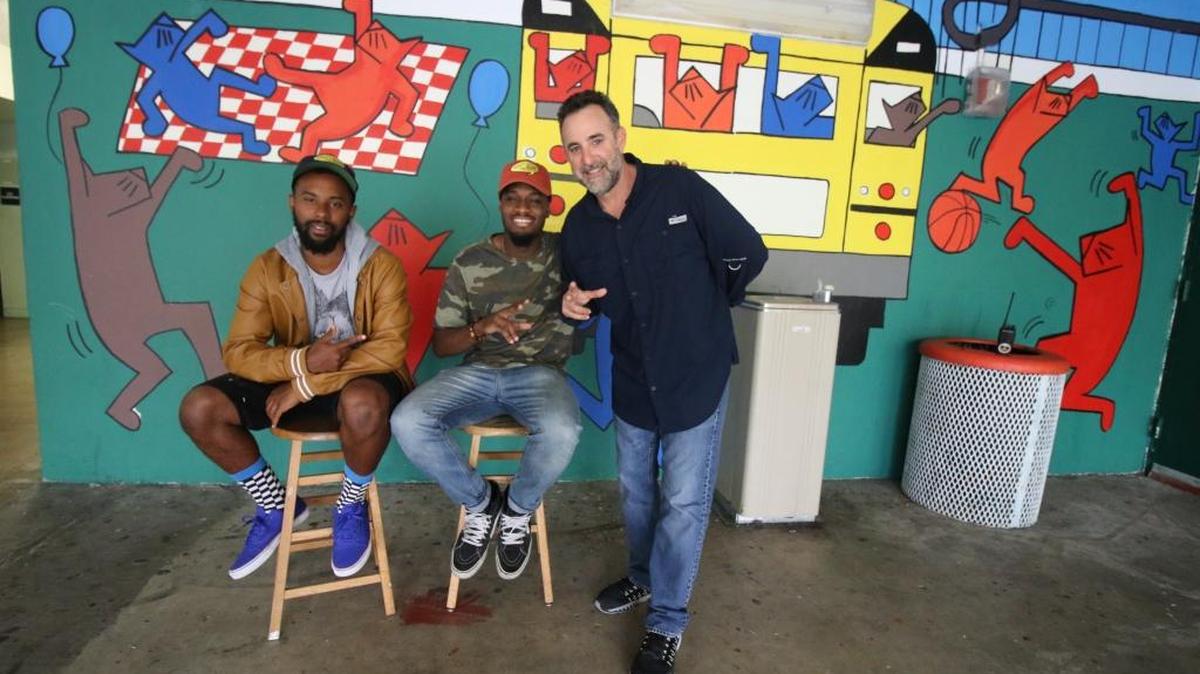 Artists Alain Georges, left, and Keyani Watkins with Activities Director Mark Barnett, right, display the finished look of Cougar's Pride, the mural located in the activities office.