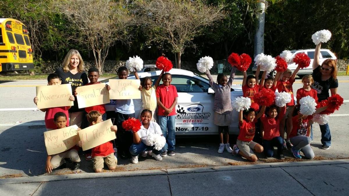 Serah'ni Nicaisse of Howard Drive Elementary School is pictured with his classmates, Principal Deanna Dalby and instructor Wendi Bosworth after receiving a ride to school in the Pace car. The school’s second graders won the Homestead-Miami Speedway Race to Read Challenge after reading the most online books districtwide.