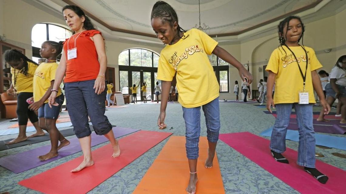 Program coordinator Dorlisa Banbanaste, with campers Cambriyah Noldon and Dakota Davis, left to right, as third and fourth graders learn "mindfulness" and methods to cope with stress in a class room led by Mindful Kids Miami during Camp Honey Shine at Carrollton School of the Sacred Heart.