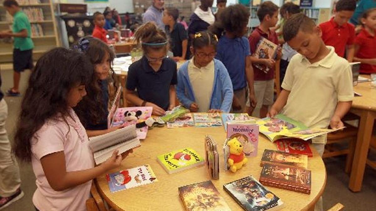 Students at South Miami Heights Elementary look at books in May 2015. The books were donated by Molina Healthcare of Florida to encourage kids to read over summer vacation.