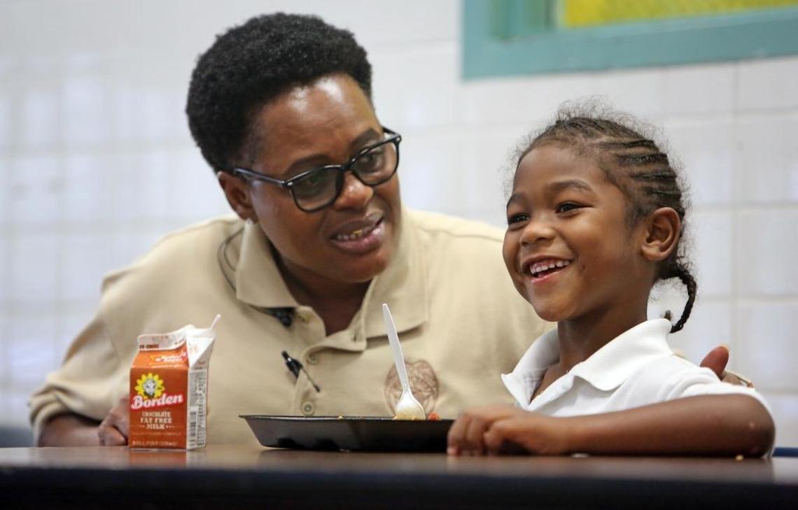 Miami-Dade police officer Linda Rowe helps new Kindergarten student, Ka'Veyon Trammell, 5, adjust to his new school during lunch time. Once a month, the Miami-Dade Police Department sends officers to Poinciana Park Elementary to have lunch with students.