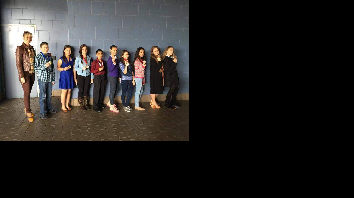 
SCIENCE FAIR WINNERS: Alex Castaneira, Sofia Gonzalez, Wendy Rodriguez, Marcelo Lopez, Lilybell Fernandez, Gabriella Perez-Lago, Kyara Cabarcas, Amy Camacho and Jocelyn Ferguson stand with their coach, Sara Saborido, after winning the State Finalist Award in the Miami-Dade County STEM Expo.
