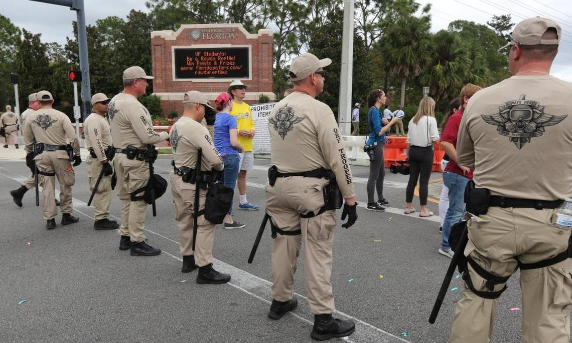 Florida Highway Patrol troopers stand ready at the entrance to University of Florida in Gainesville as hundreds of protesters march near the Phillips Center, where Richard Spencer was allowed to speak.