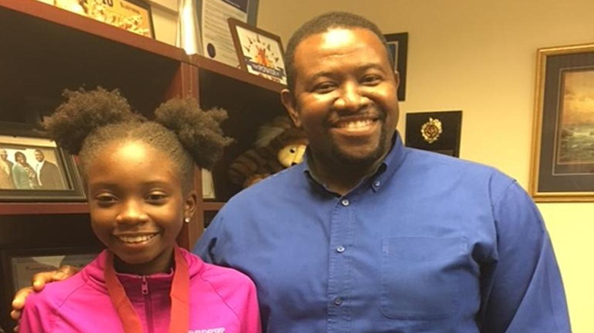 Brianna Thomas, left, of North Miami Middle School stands with school Principal Patrick Lacouty after being recognized as one of 19 students to qualify for Duke University Talent Identification Program’s seventh-grade talent search.