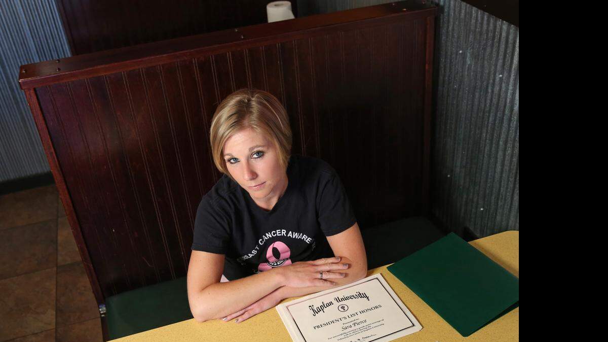 
Sara Pierce sits in a booth at the Buffalo Wings & Rings restaurant in North Port, Fla., where she works as a waitress. 
