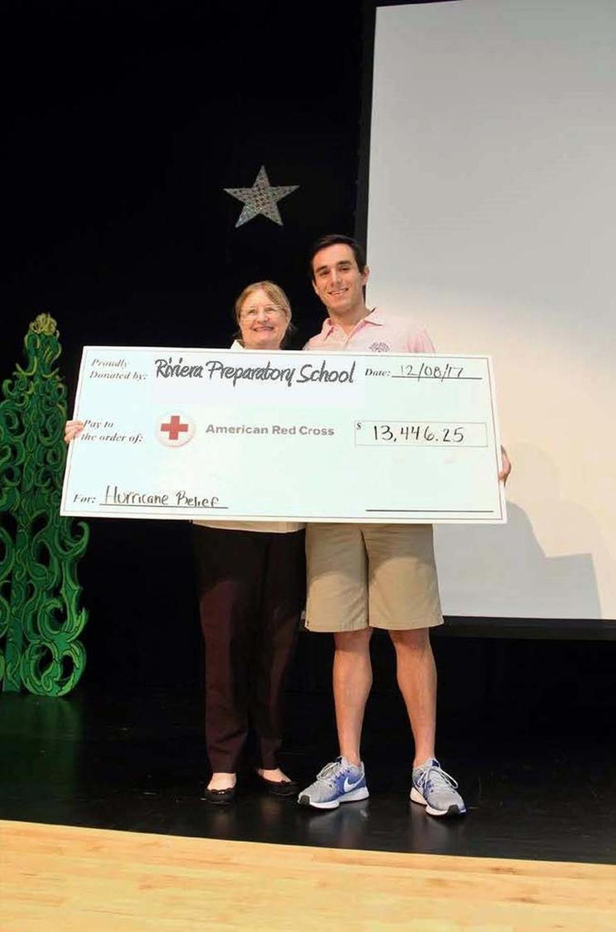 Lucas Abrante-Cosio, right, of Riviera Preparatory School presents a $13,446.25 check to Jeanne Cadwallader of the American Red Cross to help victims of hurricanes Harvey, Irma and Maria.