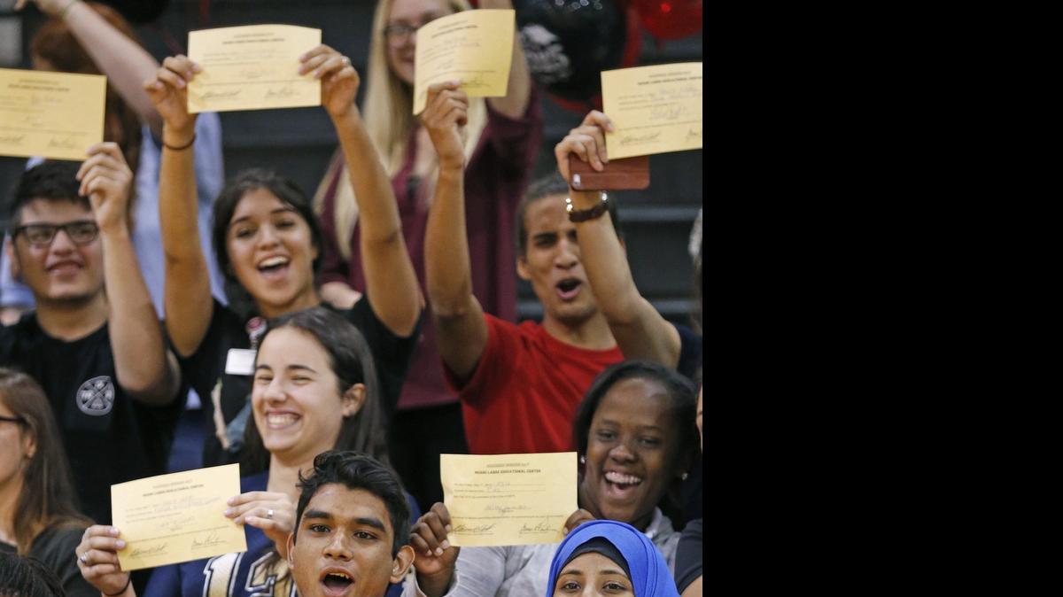
Miami Lakes Educational Center senior Giancarlo Tejeda, who is undocumented, has raised enough money for the first year of college at the University of Florida. Here he celebrates with classmates after signing his acceptance to UF during ceremony at his high school on Friday, May 1, 2015
