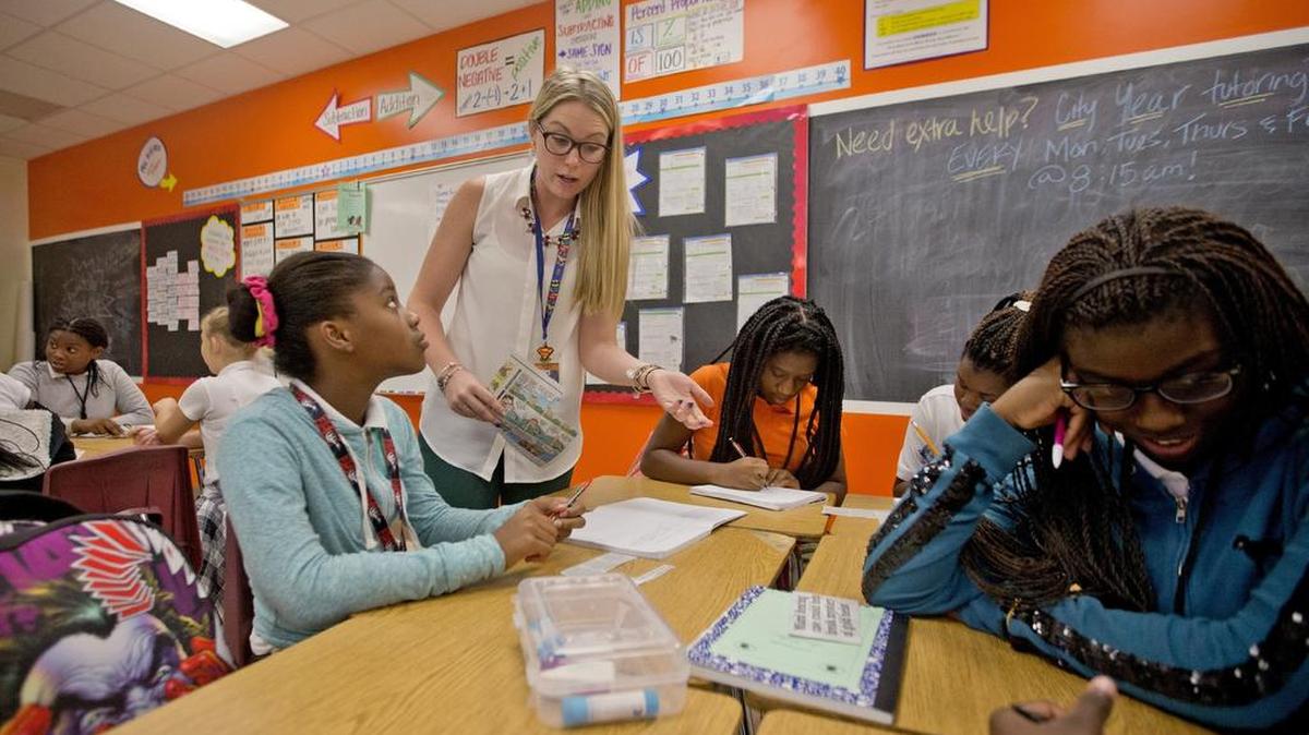 
Carol City Middle School teacher Katelyn Simoncic, center, and her students are creating the school's first newspaper by using just 11-by-7-inch paper and the school's copier.
