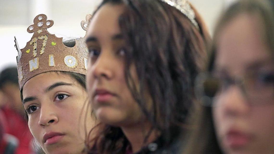 Jeorgelis Calix, 18, left, listens closely as she sits with classmate Shirley Lopez, 18, center, while attending a financial literacy presentation at Coral Gables High on Monday, April 17, 2017. The pair wore crowns as part of "Senior Spirit Week" at Coral Gables Senior High.