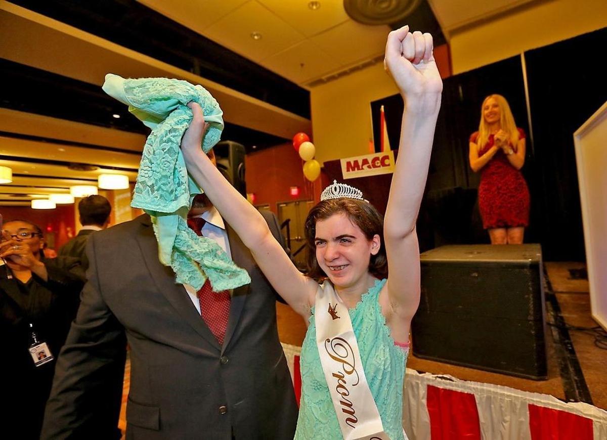 Prom Queen Lisa Sprung of Miami Coral Park Senior High raises her arms after being crowned queen at a prom for autism spectrum disorder prom at the DoubleTree by Hilton Miami Airport & Convention Center on Tuesday, May 16, 2017.