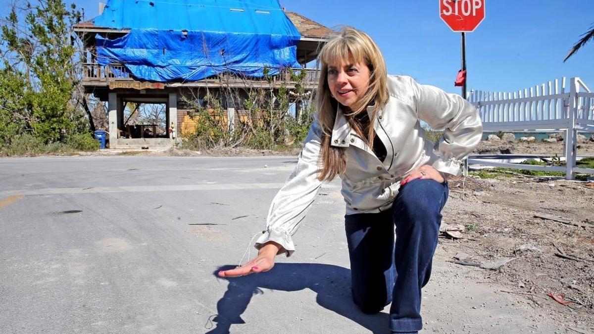 Rhonda Haag, Monroe County Sustainability Program Manager, on Jan. 19, 2018, shows the height to which the roads will be raised under a new pilot program after Hurricane Irma flooded the area on Big Pine Key.
