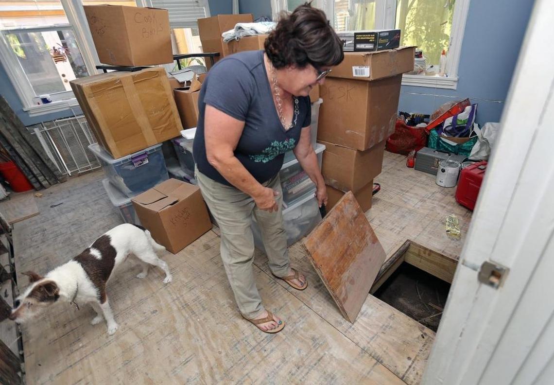 Penny Tannenbaum looks down below the flooring of one of the rooms that was flooded by Hurricane Irma.