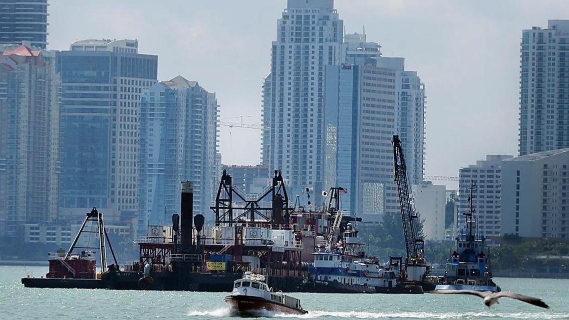 A dredging ship working on the Port of Miami Deep Dredge project is stationed in front of the Miami skyline as the deepening of the port's existing channels from its current 42 th foot depth to 50-52' is been done in preparation for the Panama Cana Expansion to allow new larger cargo ships to enter the Port of Miami in March 2015.