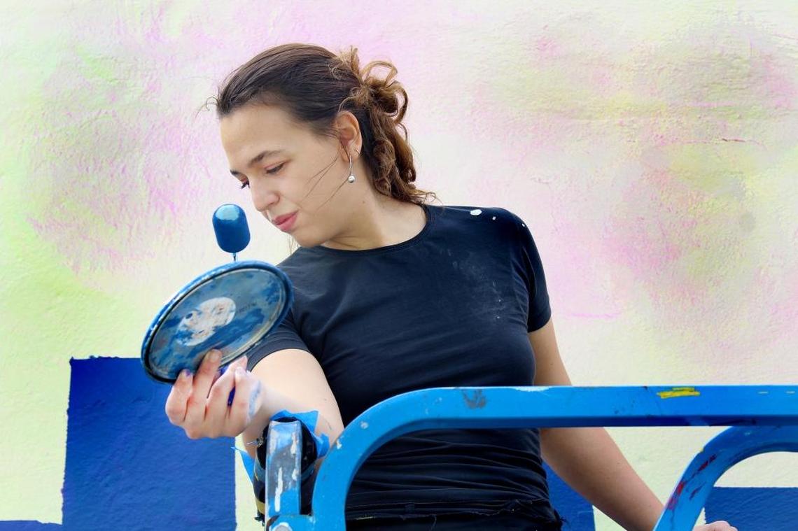 Sofia Dotta, multimedia artist and team manager for Miami Murals, assists artists Muta Vision and Odobo paint the project’s first augmented reality mural on Friday, Jan. 26, 2018. The mural is across the street from the historic City of Miami Cemetery.