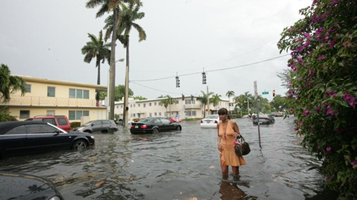 A tourist navigates a flooded Miami Beach street in 2005.