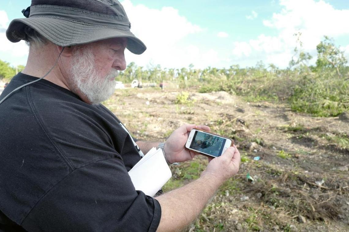 Environmentalist Al Sunshine shows a photo he took on his cellphone of a bulldozer clearing land Friday on a pine rockland where a developer wants to build a Walmart-anchored shopping center and 900 apartments.