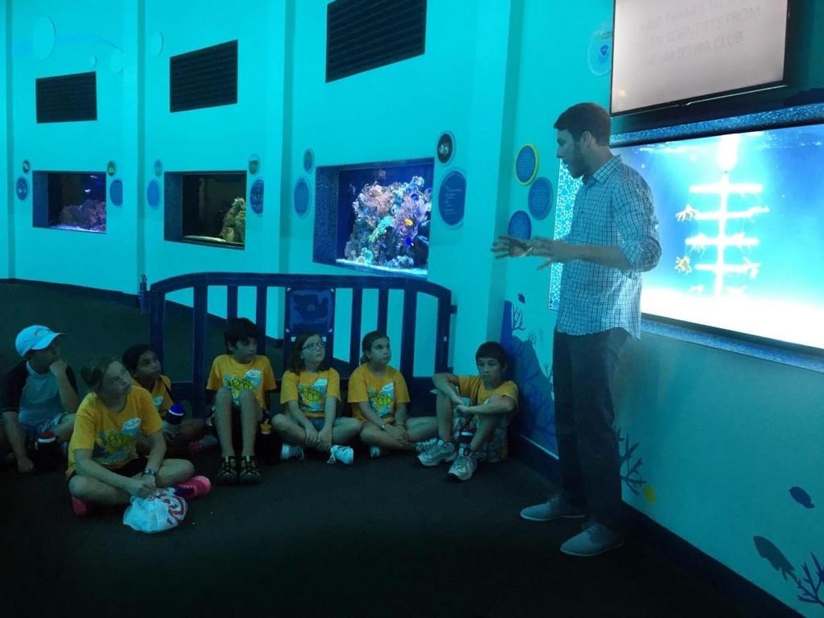 Dalton Hesley, a research associate at the University of Miami's Rosentiel School of Marine and Atmospheric Science Campus, talks to Camp Seaquarium Campers about the Rescue a Reef exhibit.