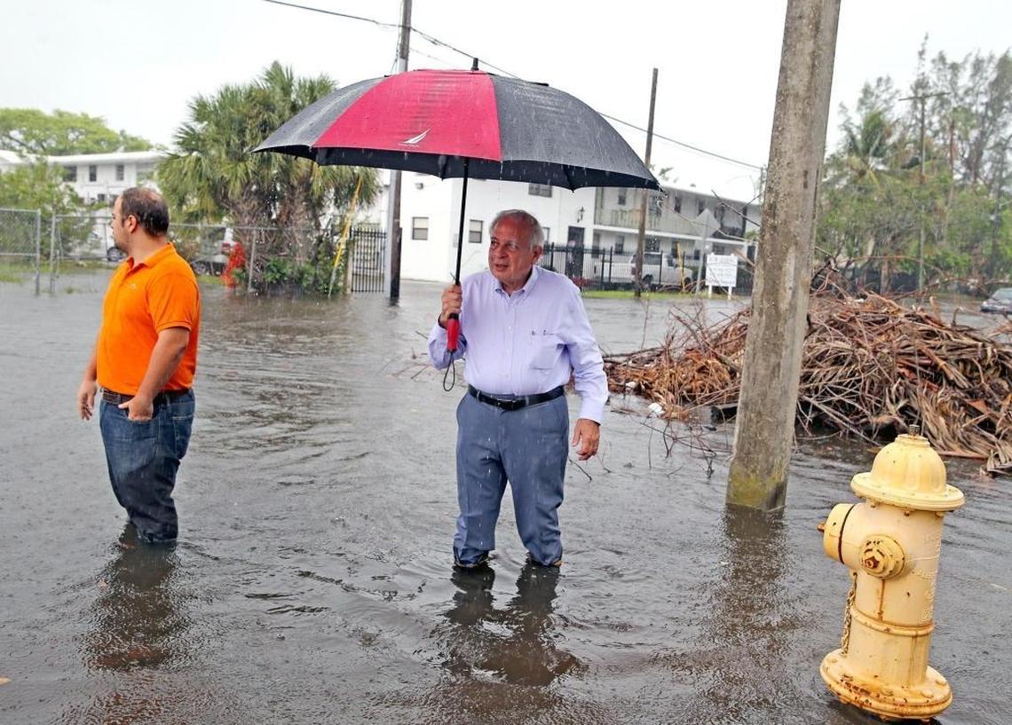 Former Miami Mayor Tomás Regalado walks down a flooded street in the Shorecrest neighborhood with his son, Jose Regalado, during a king tide last October.