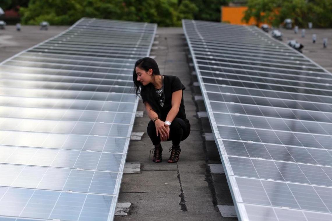 Florida International University student Chloe Castro looks for the first time at the high-tech solar panels on Camillus House that she designed as part of a class project Friday, Sept. 25, 2015, in Miami. Her assignment: design a project to translate philanthropy into everyday life, then persuade 27 classmates that hers was better than theirs.