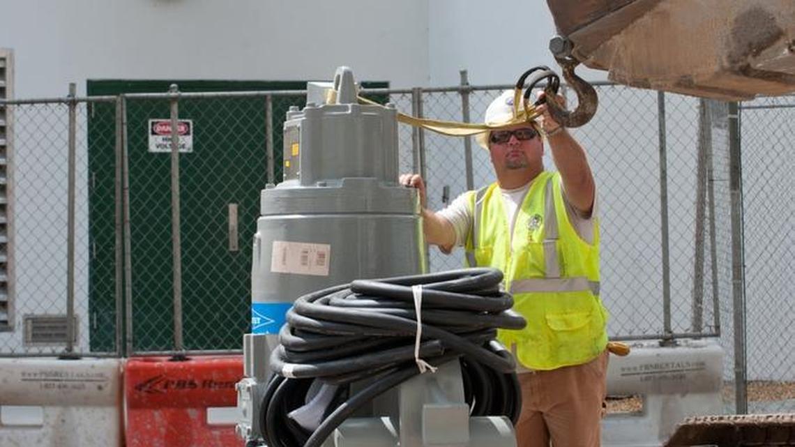 A worker prepares to move one of the storm-water pumps installed near West Avenue and Tenth Street in Miami Beach in September 2014. In response to a Miami Herald request for staff emails discussing the pumps, the city charged the paper nearly $73,000.