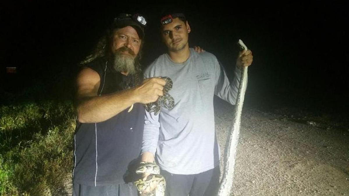 Jasson Leon, right, with fellow hunter Dusty Crum, bagged the 500th python this week in the South Florida Water Management District’s snake hunt.
