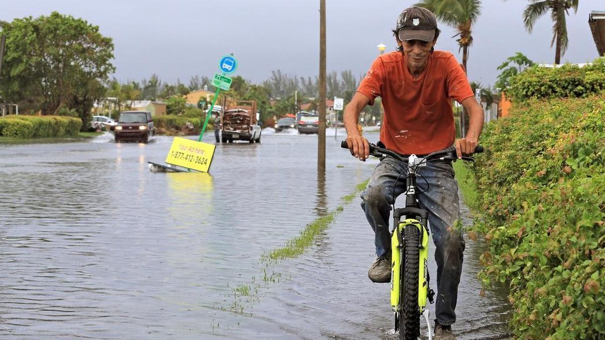 A man bikes through the flooding in the streets of Sweetwater in October.