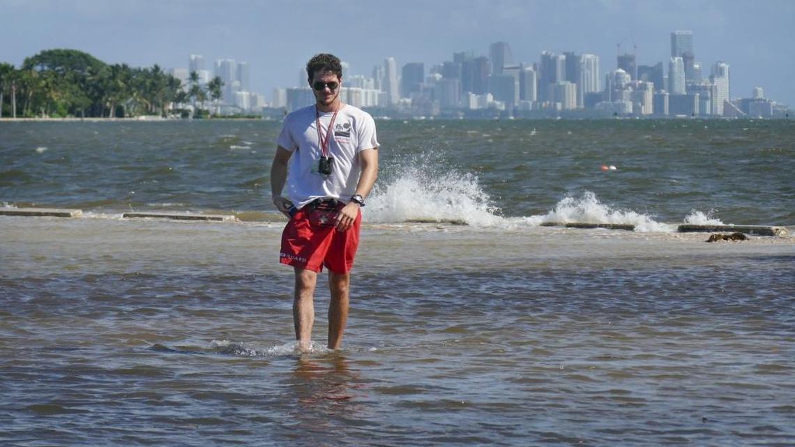 Lifeguard Anthony Cantillo walks along a flooded sidewalk at Matheson Hammock Park in October after a seasonal king tide flooded much of the park.