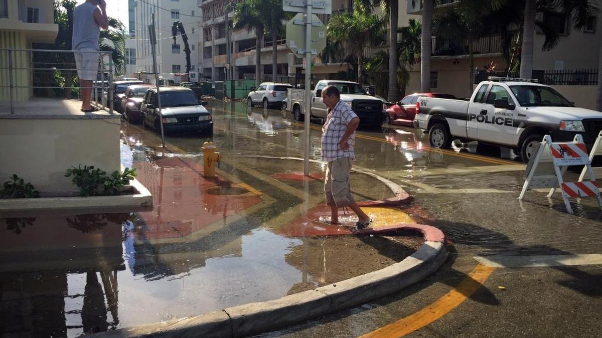 A man wades along Indian Creek Drive and 30th Street in September 2015 after a seasonal king tide flooded the area.