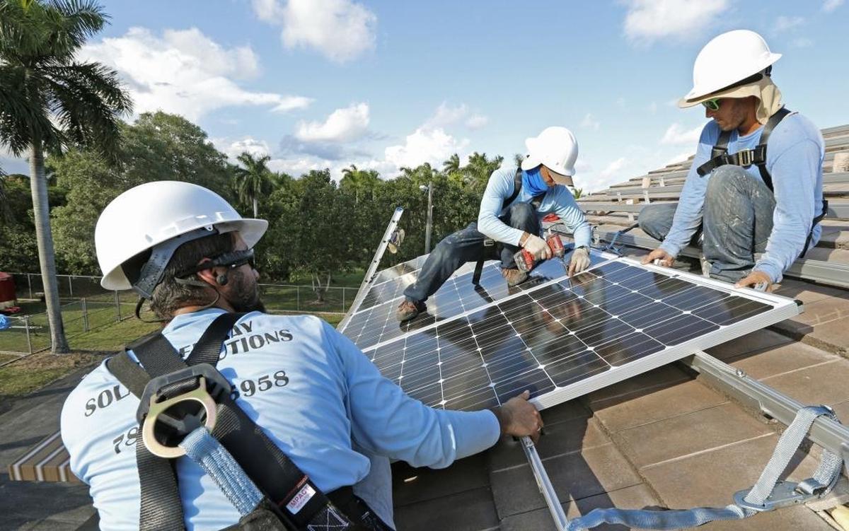 From left, Joseph Molina, Martin Cabrera and Luis Vergara install solar panels in South Miami-Dade County. This year, the city of South Miami began requiring solar panels on all newly constructed homes.