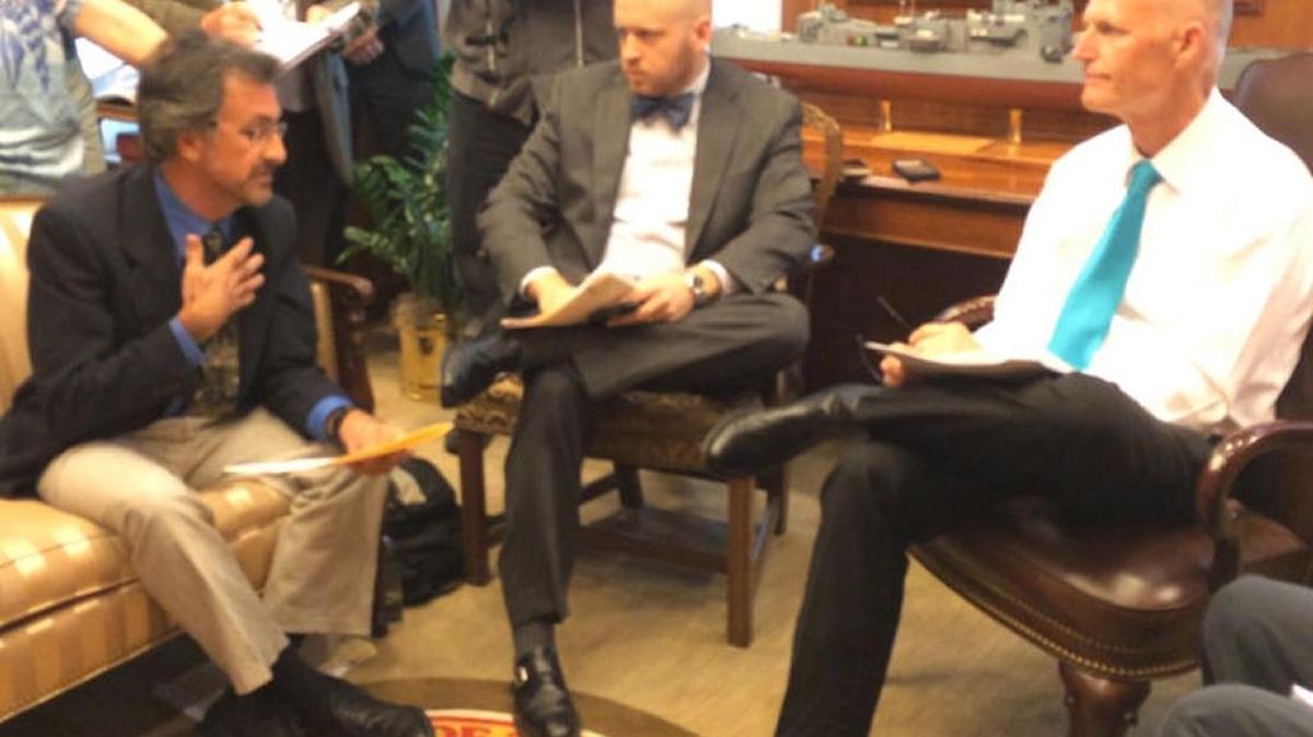 Eckerd College marine science professor David Hastings, left, speaks to Gov. Rick Scott, right, and his aide, Noah Valenstein, during an Aug. 20, 2014, meeting about why Florida should act to offset the impact of climate change.