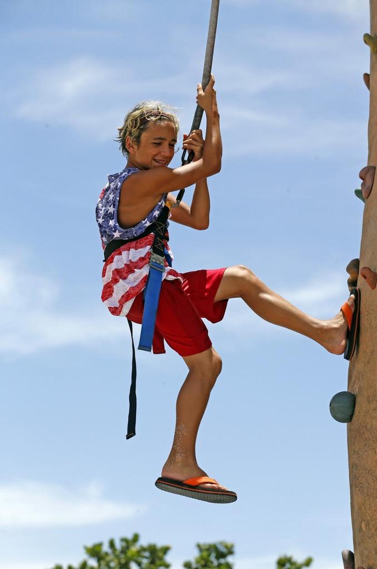 Giovanni Sanna-Lendi 12, repels from a rock climbing wall as he celebrates our nation's birthday this year at an outdoor festival at Miami Beach's North Shore Bandshell Park with day-long entertainment and activities for the entire family, July 4, 2016.
