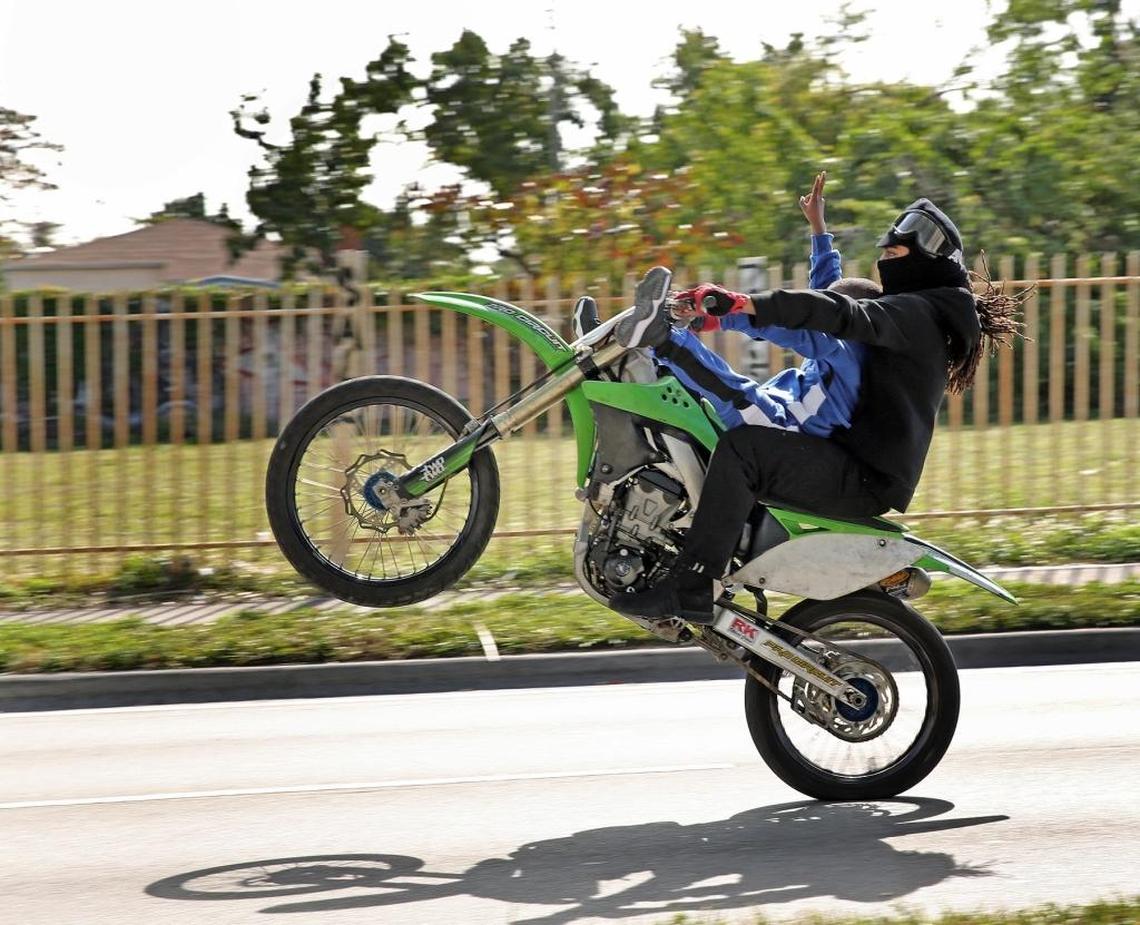 A lone biker with a young child pops a wheelie on Northwest 62nd Street on Martin Luther King Day on Monday afternoon, Jan. 15, 2018.