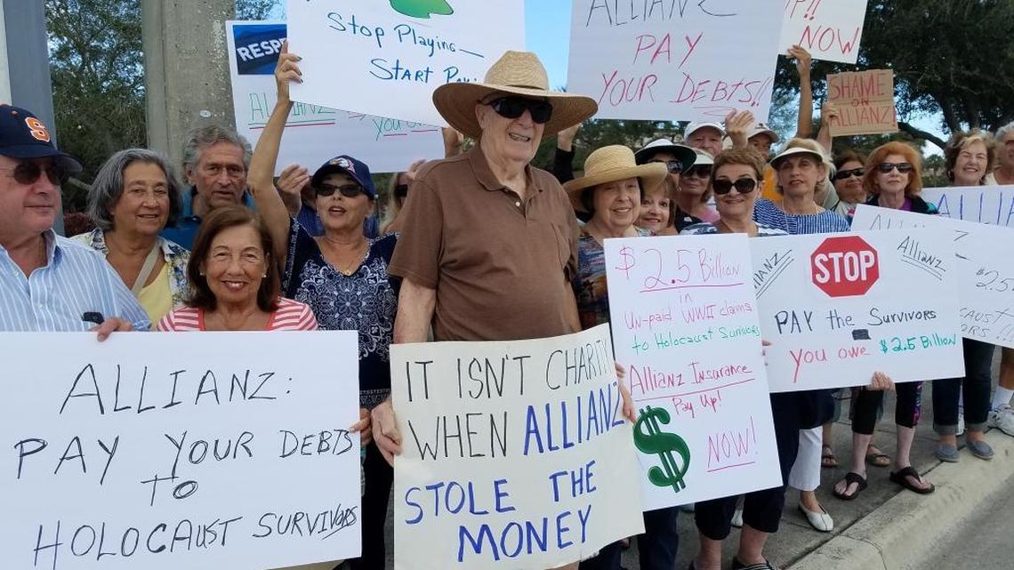 Protesters hold signs Sunday at the Allianz PGA Golf Championship at Broken Sound Club in Boca Raton to demonstrate against the German tournament sponsor for not fully paying the life insurance policies of Holocaust victims.