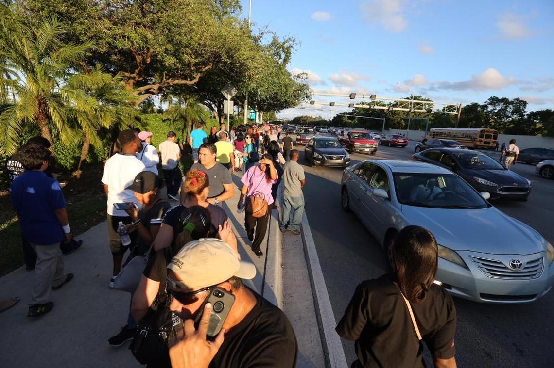 A mass of people and cars begin to leave Hard Rock Stadium after being told to come back Wednesday, after Tuesday’s emergency food relief program closed early due to full capacity.