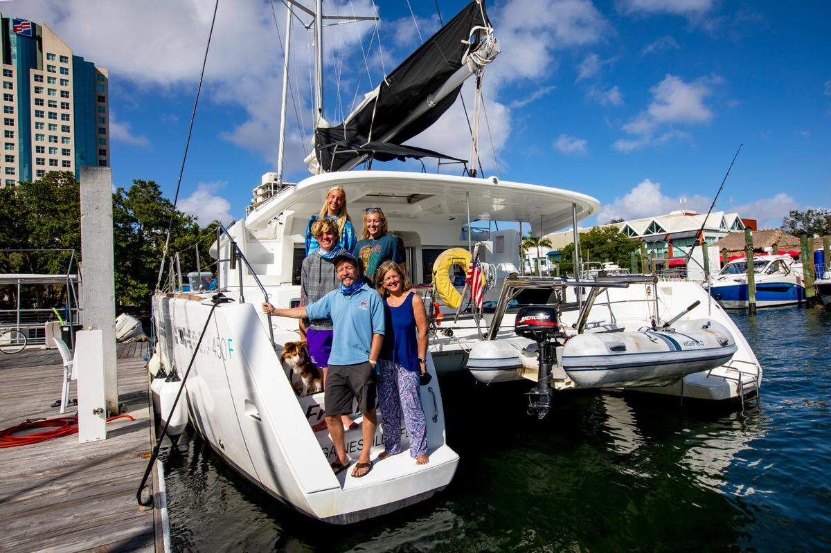 Annapolis natives Sarah Grace Clifton, 18, Tad Clifton, 16, Mac Clifton, 21, Tip Clifton, 57, and Robyn Clifton, 57, pose for a photo on their chartered boat at Shake-A-Leg Miami’s marina in Coconut Grove, Florida, on Wednesday, Dec. 30, 2020. After surviving pancreatic cancer almost seven years ago, Tip was left with some balance and spacial difficulties, and unable to sail anymore, so he now watches his youngest daughter, Sarah Grace, race in his old Laser in the 2020 Orange Bowl International Youth Regatta.