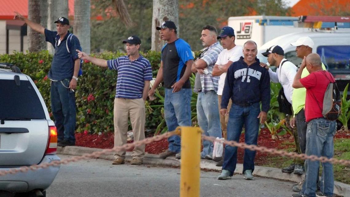 Day laborers, some of whom are undocumented immigrants looking to work, scramble for jobs offered by contractors coming to Home Depot to pick up workers early Tuesday, Feb. 28, 2017.
