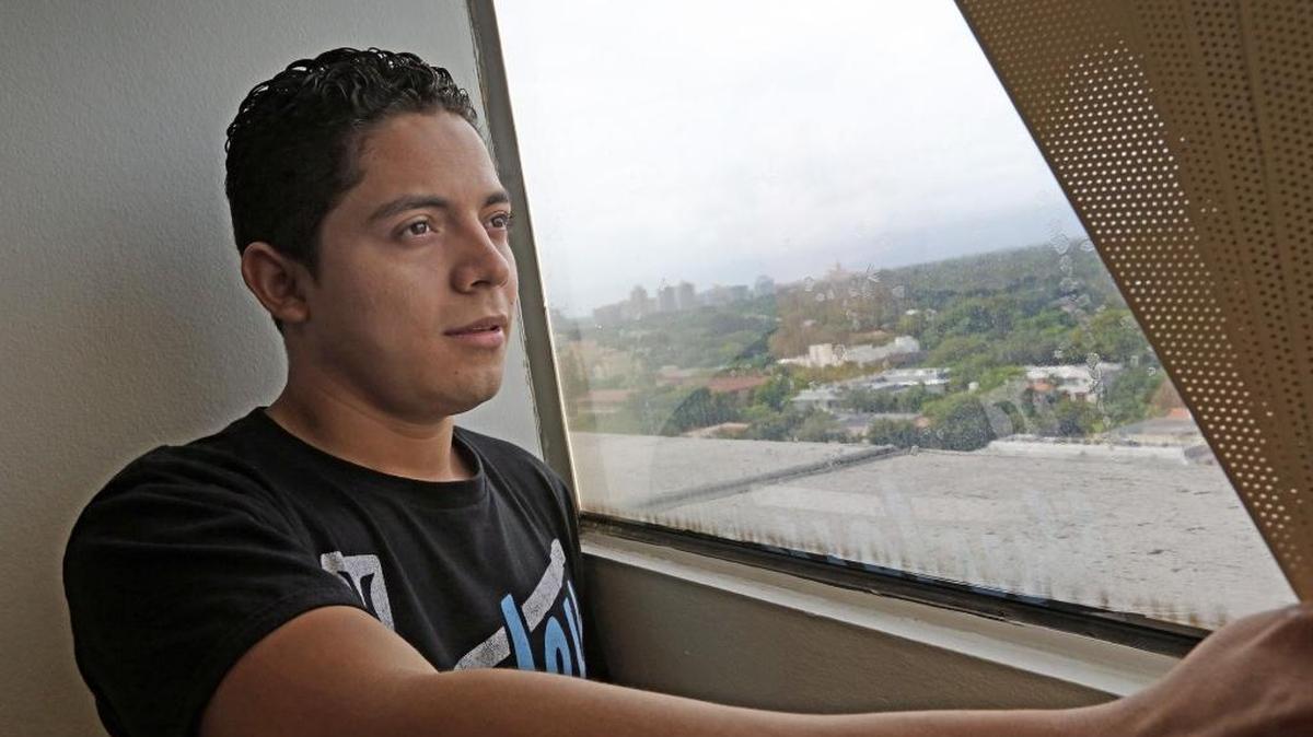 Brady Cano, 17, looks out the window from the law office of Eduardo Soto, his immigration lawyer in Coral Gables after getting his green card. Cano, from Guatemala crossed the Mexican border alone but now gets to stay in the United States.