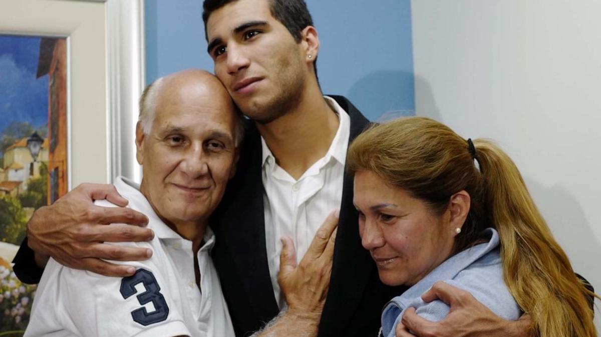 Marco Coello hugs his parents Armando Coello and Dorys Morillo de Coello at the Blandon Law office in Weston following his release.