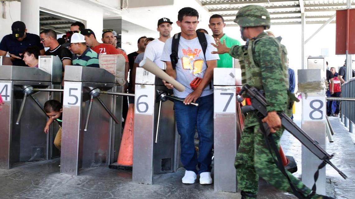 A Mexican soldier stops Cuban immigrant Reinier Aguila Esquivel and other Cubans stranded in Nuevo Laredo, Mexico as they try to pass to the international bridge, following a rally, marching from Plaza Juarez to the International Bridge, on Saturday, April 8, 2017.