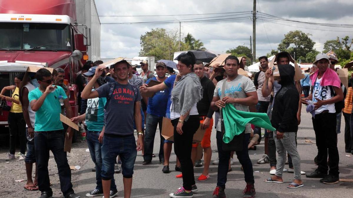 At the border crossing in Paso Canoas, a large group of Cubans block passage Friday as they protest authorities not letting them enter Nicaragua. The place is filled with people, including many sleeping on the floor.