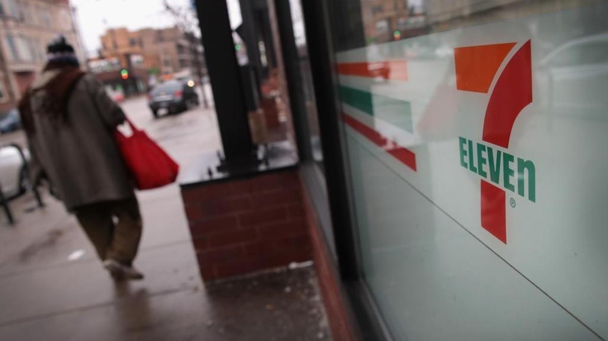 A pedestrian walks past a 7-Eleven store on Wednesday, Jan. 10, 2018, in Chicago, Illinois. Immigration officials raided nearly 100 7-Eleven stores across the country Wednesday morning checking the immigration status of store employees.