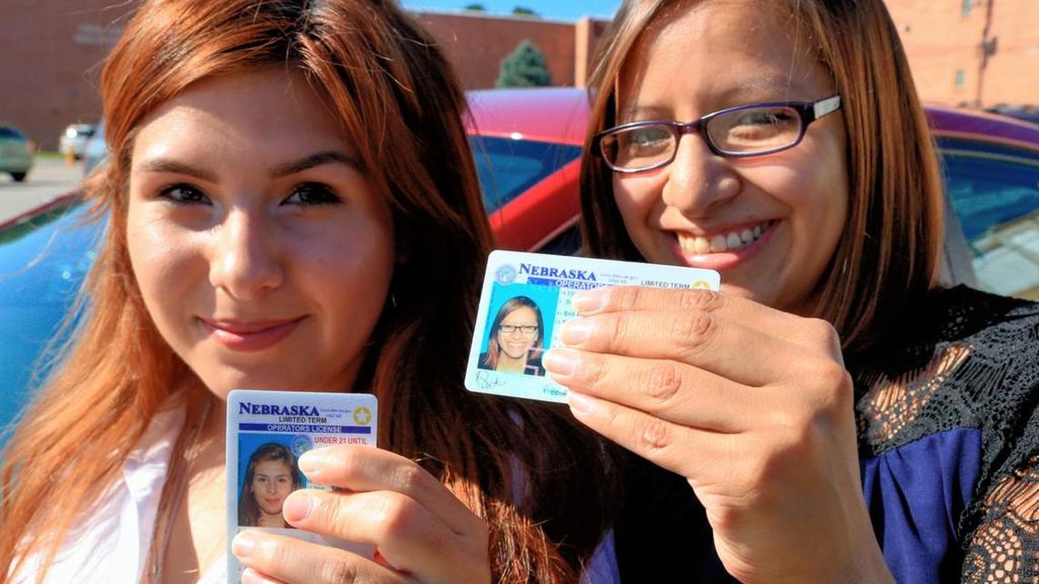 
Yajaira Gonzalez, left, a 20-year-old whose parents brought her to Omaha from Mexico shortly before her 9th birthday, and Fatima Flores-Lagunas, 24, a University of Nebraska Omaha junior, pose for a photo in front of Fatima's car with their drivers licenses in Omaha, Neb., Friday, Aug. 7, 2015. Nebraska has issued 1,300 driver’s licenses to youths who were brought into the country illegally as children since the state became the last in the nation to let them apply. 
