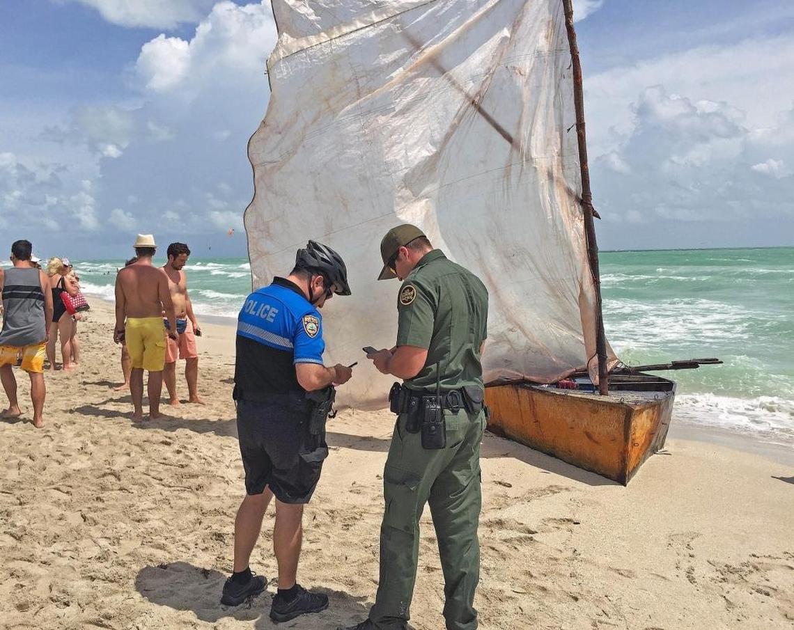 A City of Miami Beach Police Officer and a U.S. Border Patrol agent at the scene on 16th street and Collins Avenue in Miami Beach where a makeshift sailboat with twelve cuban rafters and a dog arrived after being in the high seas for 6 days on Sept. 15, 2015.