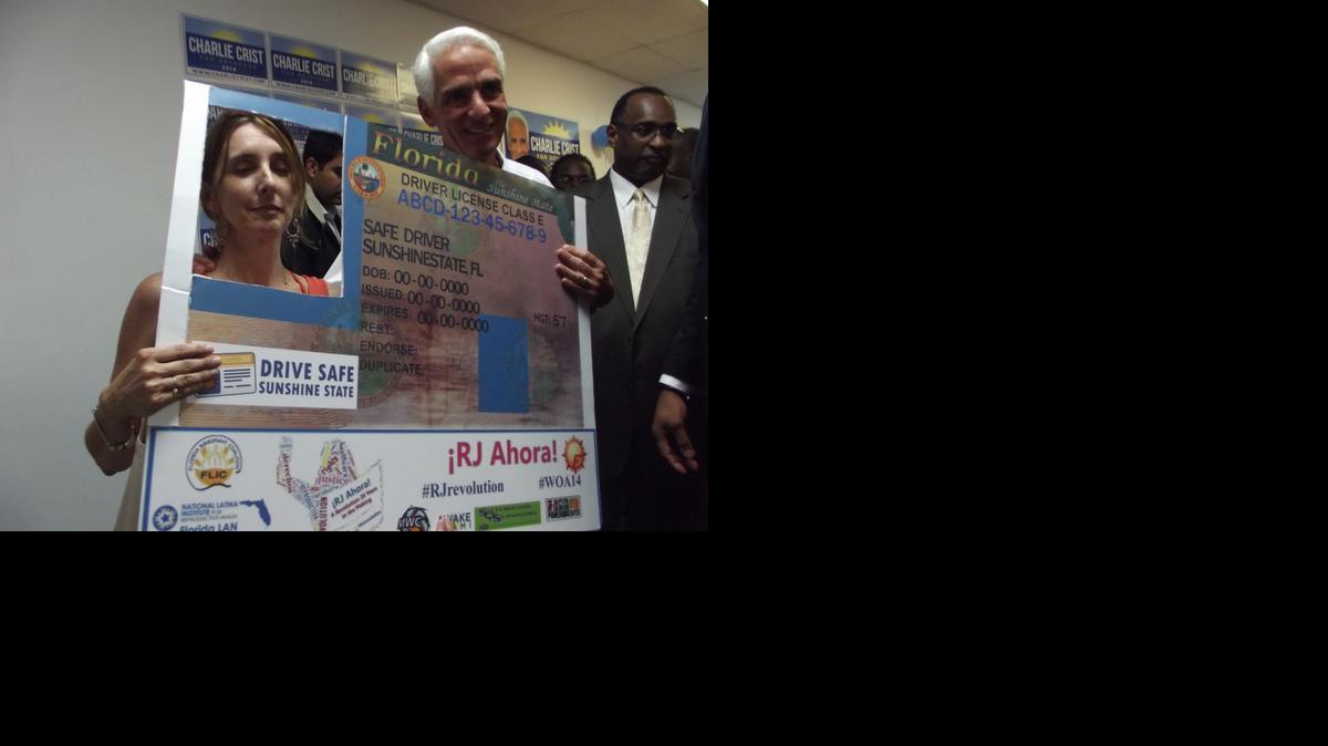 
Gubernatorial candidate Charlie Crist stands next to immigrant rights activist Maria Bilbao as she poses for a picture with a mock driver’s license during a recent Miami Gardens event promoting access to Florida driver’s licenses for undocumented immigrants.
