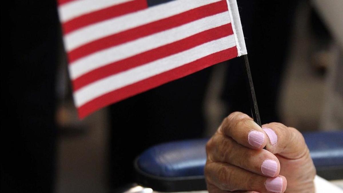 A U.S. citizen applicant holds the American flag during a ceremony in 2016.,