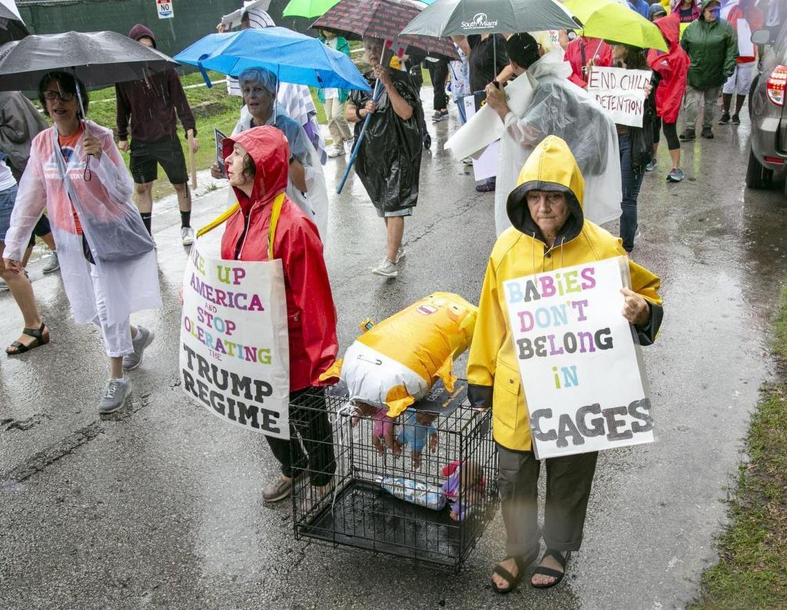 Retired school teachers from Tampa, FL, Diane Rodriguez, 73, and Mimi Pike, 67, hold a dog cage and signs during a march at the Homestead Temporary Shelter for Unaccompanied Children on Sunday, June 16, 2019.