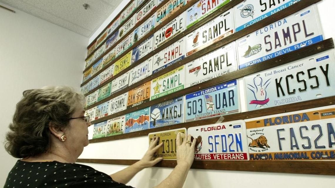 June Ester, community liaison for tax collector Doris Maloy, puts up new license plates at the tag office in Tallahassee in 2003 file photo.